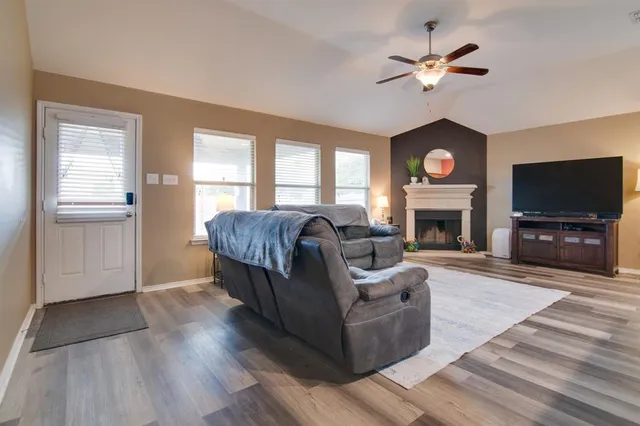 a living room with furniture a fireplace and a flat screen tv