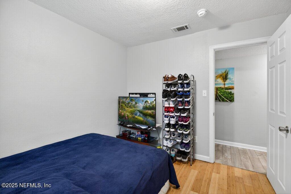 1860 Embassy Drive Jacksonville, FL 32207 - Photo 17 of 53 a bedroom with a bed and a wooden floor