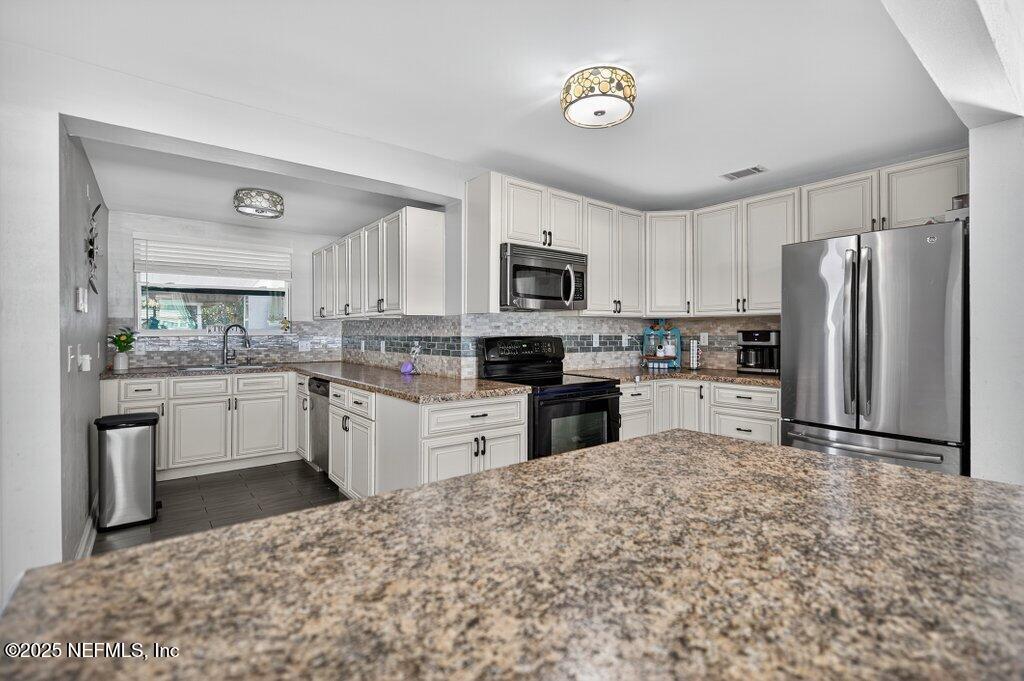 1860 Embassy Drive Jacksonville, FL 32207 - Photo 33 of 53 a kitchen with granite countertop a refrigerator stove top oven and sink