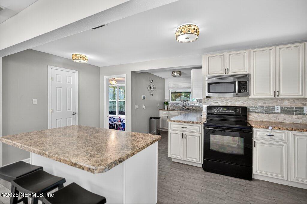 1860 Embassy Drive Jacksonville, FL 32207 - Photo 34 of 53 a kitchen with stainless steel appliances granite countertop a stove top oven a sink and a refrigerator