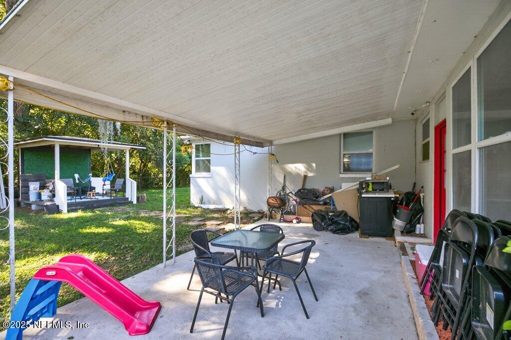 1860 Embassy Drive Jacksonville, FL 32207 - Photo 47 of 53 a view of a patio with table and chairs potted plants and floor to ceiling window