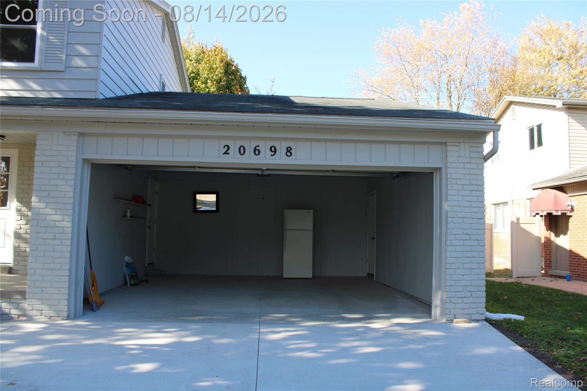 20698 Coachwood Road Riverview, MI 48193 - Photo 3 of 37 Two-car garage featuring painted brick siding and a concrete floor