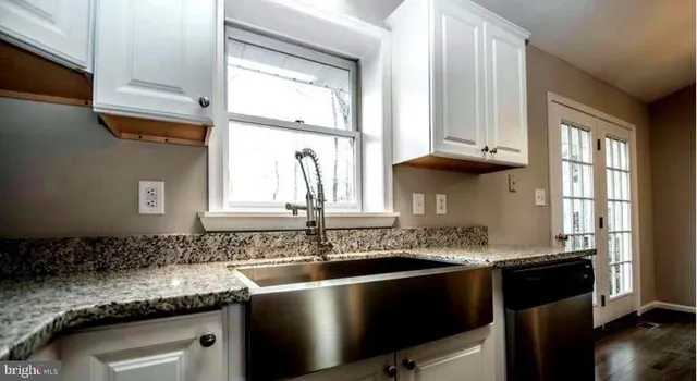 a kitchen with stainless steel appliances granite countertop a sink a stove and a microwave