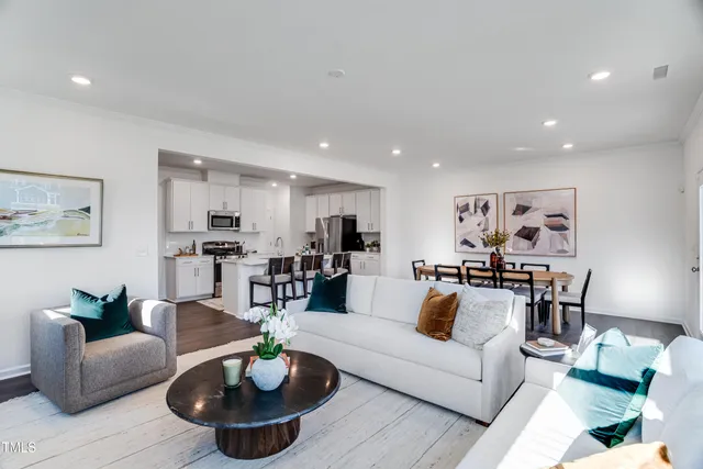 a living room with furniture and a dining table with kitchen view