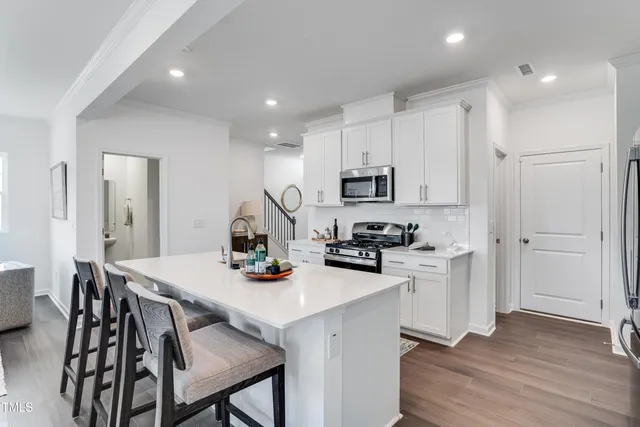 a kitchen with a sink a stove and chairs