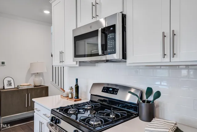 a kitchen with kitchen island a stove and a white cabinets
