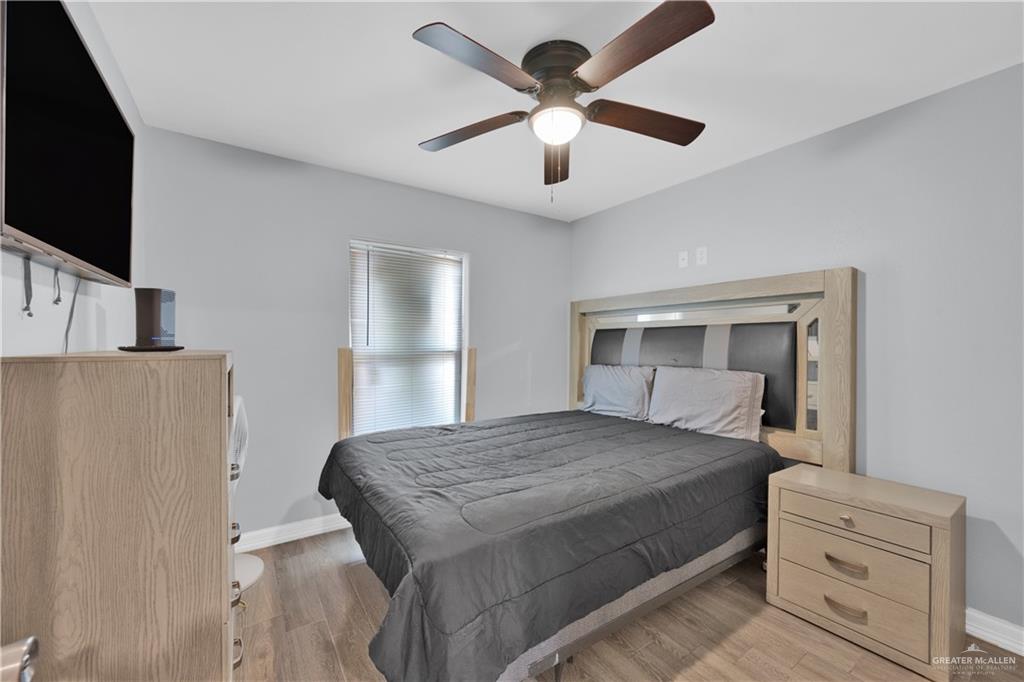 405 East Guerra Street Rio Grande City, TX 78582 - Photo 19 of 33 Bedroom with baseboards, light wood-type flooring, and ceiling fan