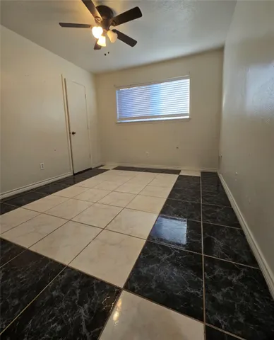 an empty room with a ceiling fan and fan