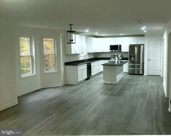 a kitchen with stainless steel appliances kitchen island granite countertop a sink counter space and a window