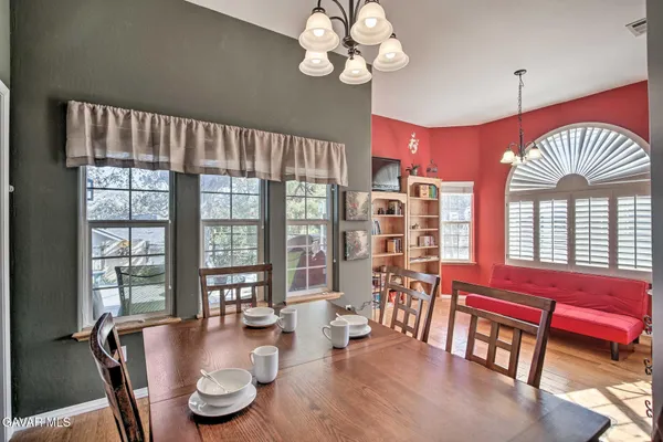 a view of a dining room with furniture a chandelier and wooden floor