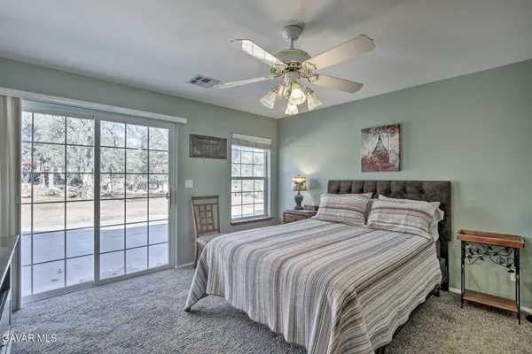 a spacious bedroom with a large bed and a chandelier