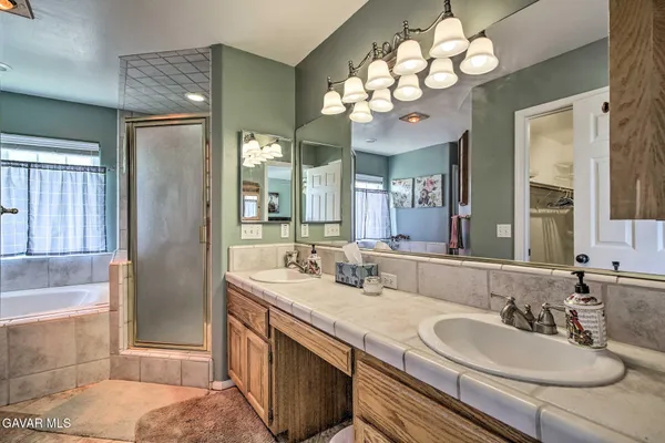 a bathroom with a granite countertop sink a large mirror and a shower