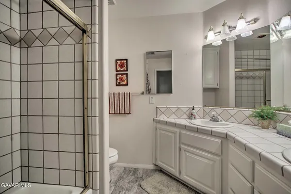 a bathroom with a granite countertop sink a toilet and mirror
