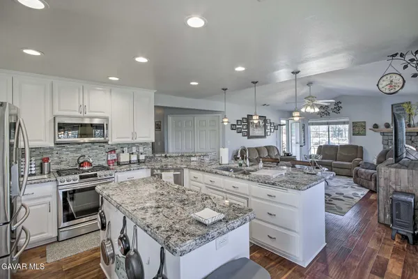 a kitchen with stainless steel appliances granite countertop a stove oven and a white cabinets