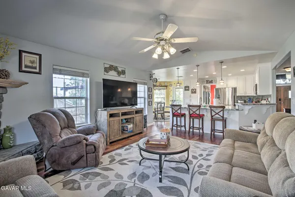 a living room with furniture kitchen view and a flat screen tv