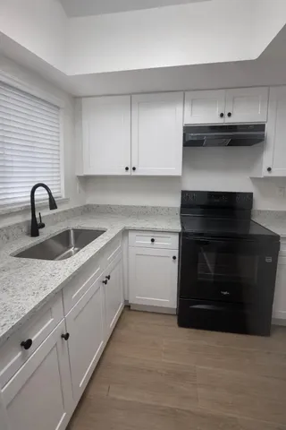 a kitchen with granite countertop a stove and a sink