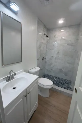 a bathroom with a sink a toilet and shower