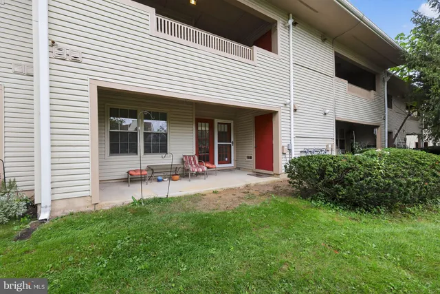a view of a chair and table in backyard of the house