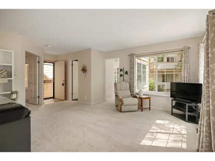 a living room with furniture a flat screen tv and large window