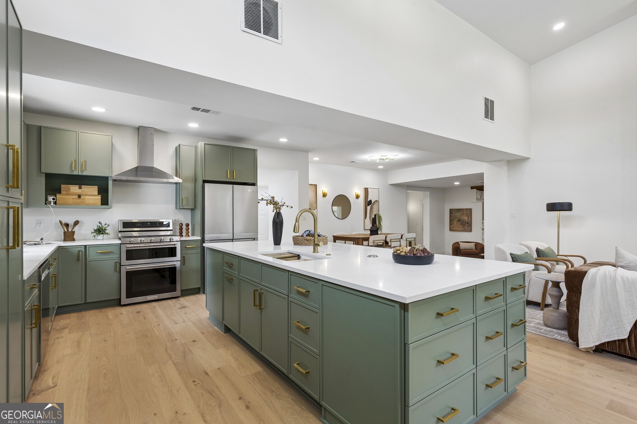 Stunning Designer Kitchen. Sage Green Cabinetry, Quartz Countertops, Brass Hardware, Stainless Steel Appliances, and a Massive Center Island