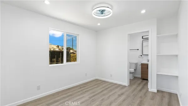 an empty room with wooden floor and a window