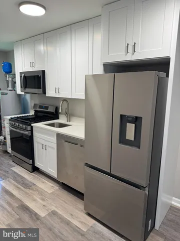 a kitchen with a refrigerator sink and cabinets
