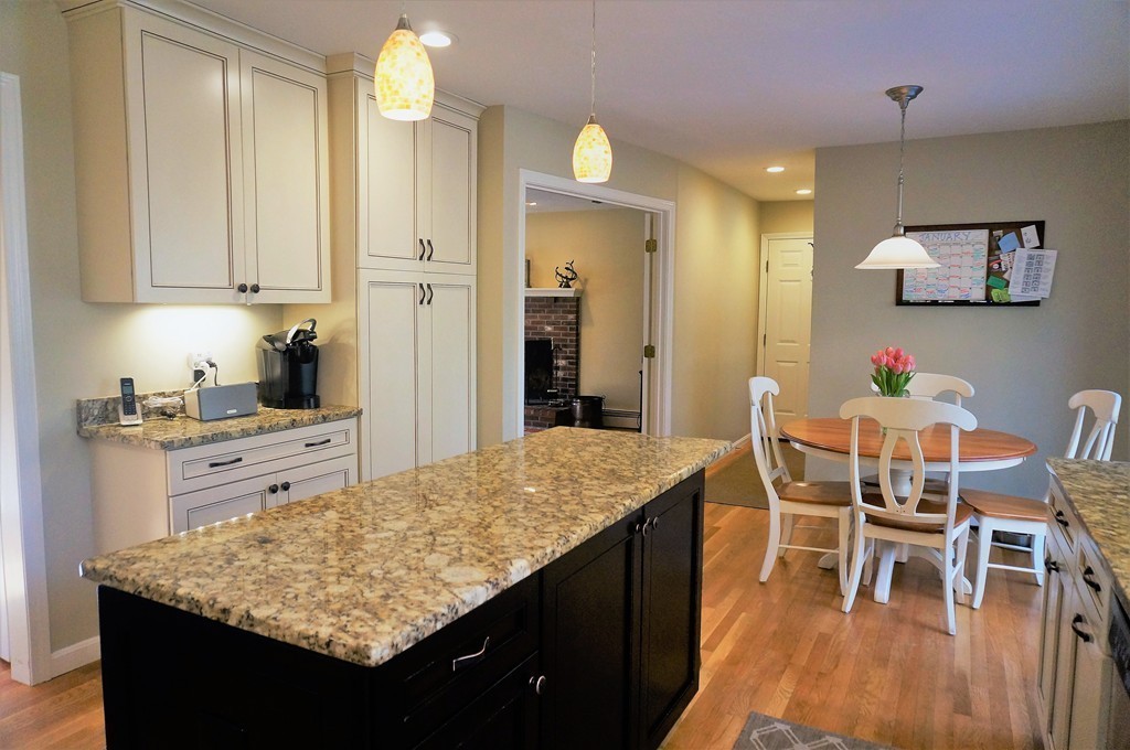 12 Barbara Road Sudbury, MA 01776 - Photo 9 of 26 a kitchen with granite countertop kitchen island cabinets and wooden floor