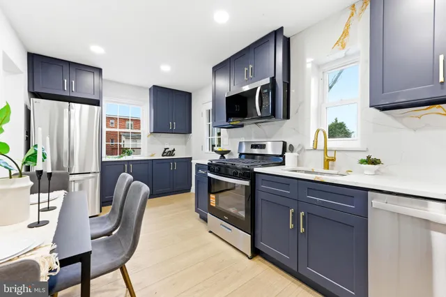 a kitchen with stainless steel appliances granite countertop a stove a microwave a sink and cabinets