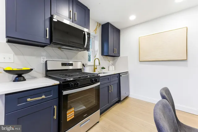 a kitchen with stainless steel appliances granite countertop a stove a microwave a sink a dining table and chairs