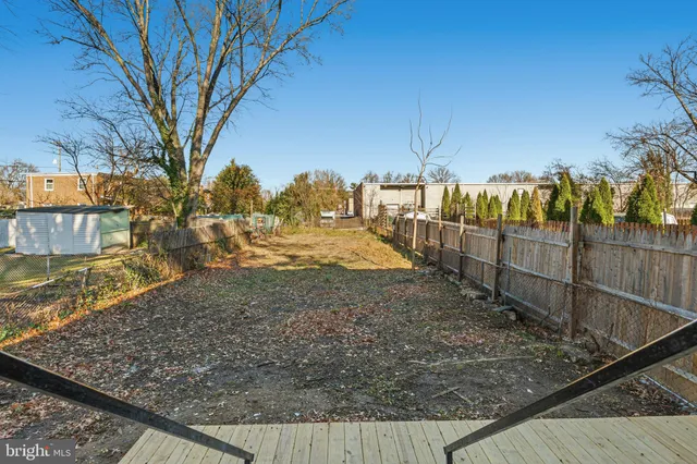 a view of a balcony with wooden floor and iron fence