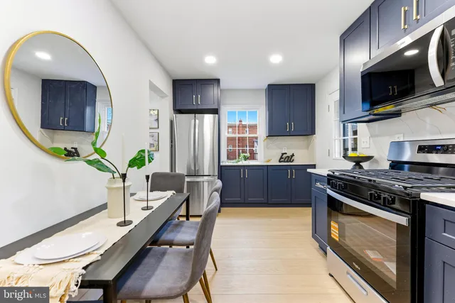 a kitchen with stainless steel appliances granite countertop a stove top oven a sink dishwasher a dining table and chairs with wooden floor