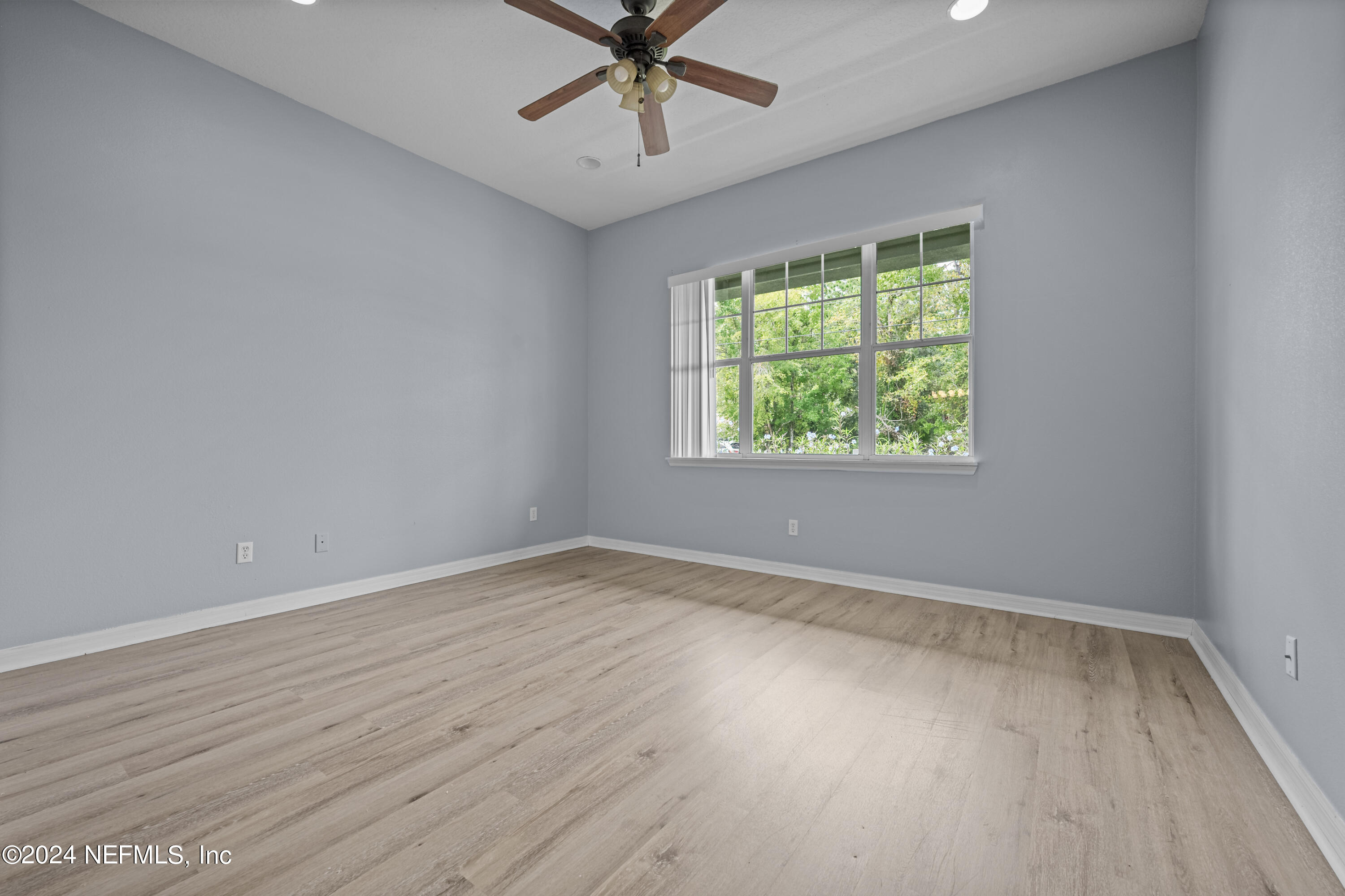 26 Zonal Geranium Trail Palm Coast, FL 32164 - Photo 19 of 35 an empty room with wooden floor chandelier fan and windows