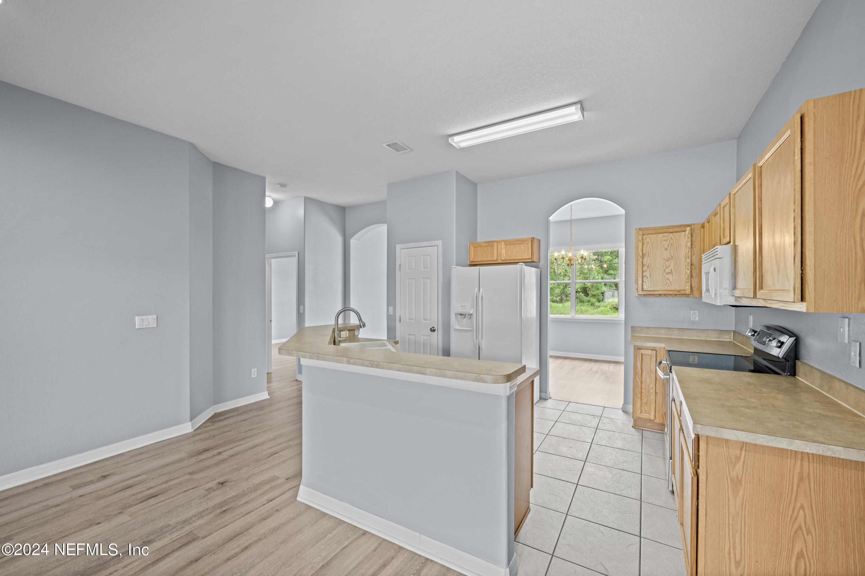26 Zonal Geranium Trail Palm Coast, FL 32164 - Photo 10 of 35 a view of a kitchen with kitchen island a sink stainless steel appliances wooden floor and a window