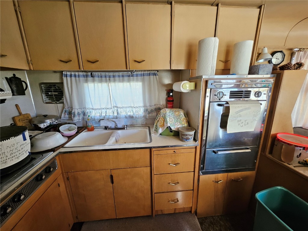 1404 Buffalo Ridge Road Como, CO 80432 - Photo 25 of 50 a kitchen with stainless steel appliances a sink a stove a refrigerator a sink a counter space and cabinets