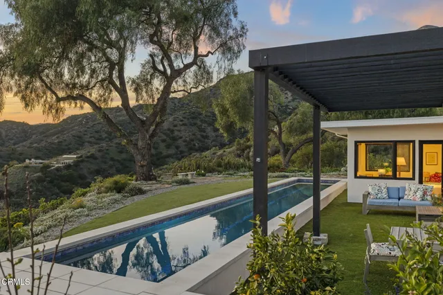 a roof deck with table and chairs under an umbrella