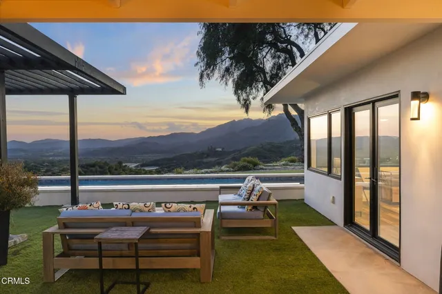 a front view of house with yard and trees in the background