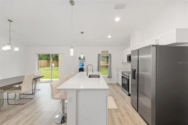 an aerial view of residential houses with outdoor space and trees