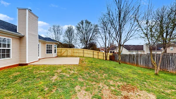 a view of a yard with a house and a large tree