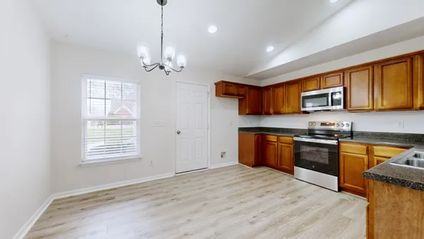 a kitchen with stainless steel appliances granite countertop a stove a sink dishwasher a refrigerator and a microwave oven