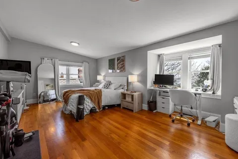 a bedroom with furniture window and a flat screen tv