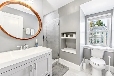 a bathroom with a toilet a sink and a mirror