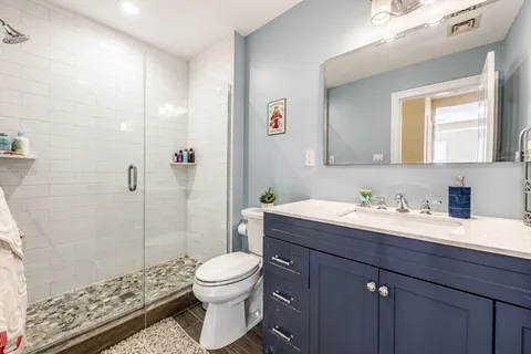 a bathroom with a granite countertop sink a toilet and a mirror