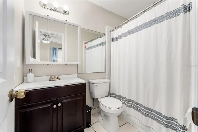 a bathroom with a sink a toilet and shower curtain