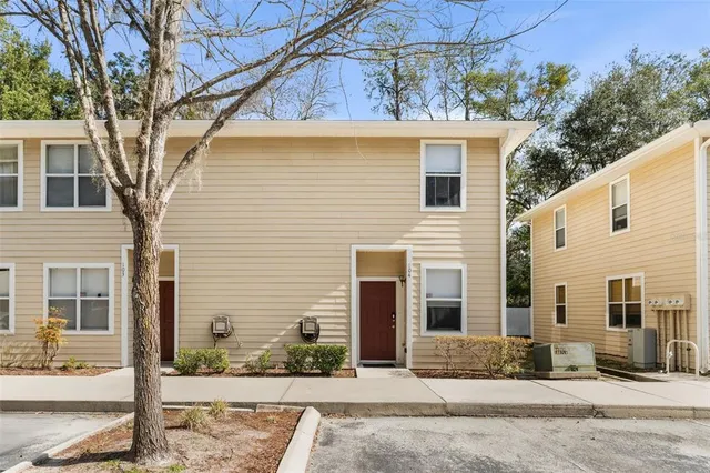 a view of a house with a tree in front of it