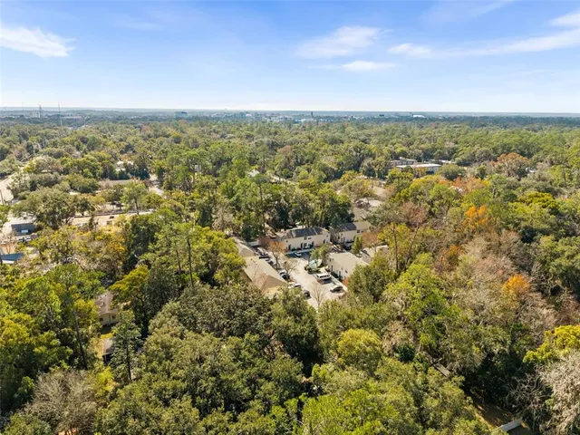 an aerial view of residential houses with city and green space