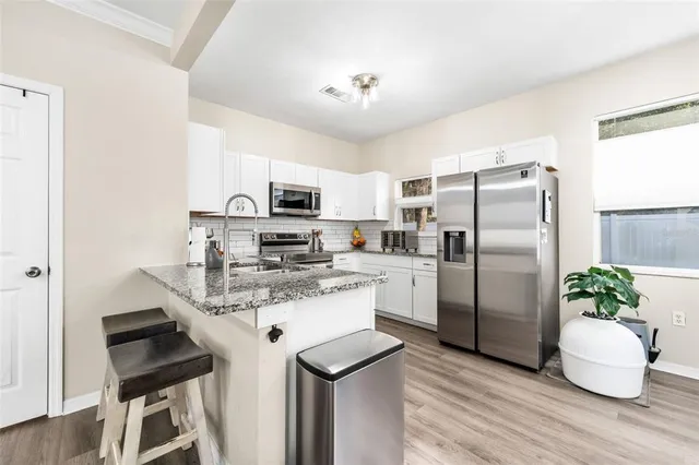 a kitchen with a refrigerator a microwave a stove and cabinets