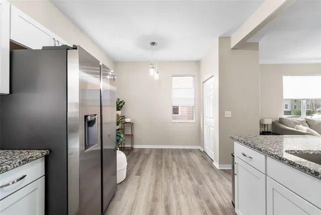 a bathroom with a granite countertop sink a refrigerator and a mirror
