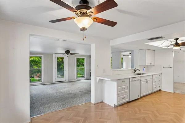 a large kitchen with stainless steel appliances granite countertop a stove and a view of living room