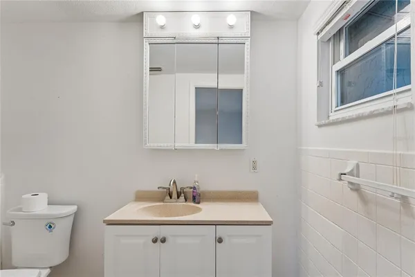a bathroom with a sink toilet and mirror