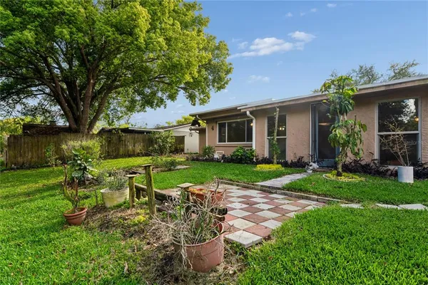 a view of a house with backyard sitting area and garden
